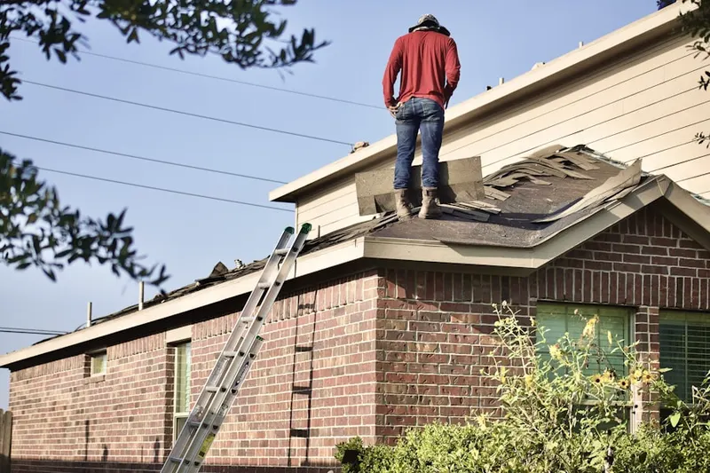 Professional roofer working on a residential roof in Brewster Hill
